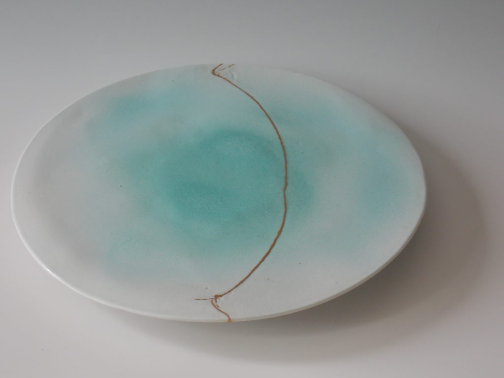 plat rond couleur céladon avec réparation kintsugi en "mother of pearl"